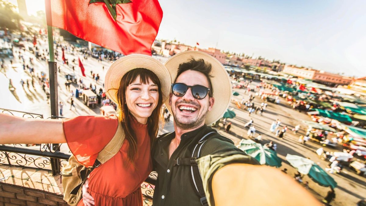 Happy tourists couple visiting Jamaa el-Fna market Marrakech, Morocco